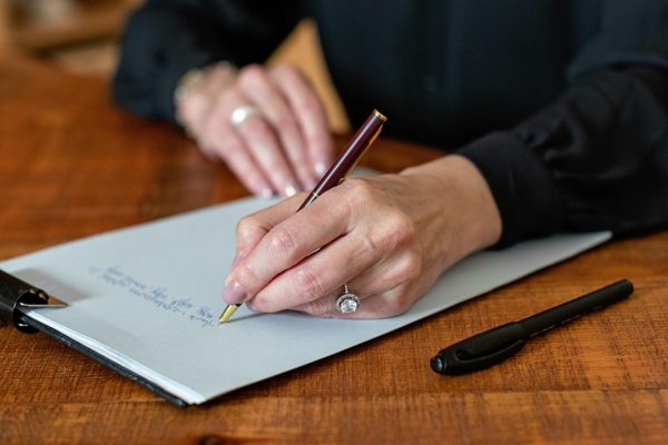pexels-photo-8871939-8871939 Professional woman writing on clipboard with a pen in a workplace setting.
